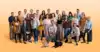 Groepsfoto van 25 digital marketing experten en de kantoorhond op een wit naar oranje gradient achtergrond